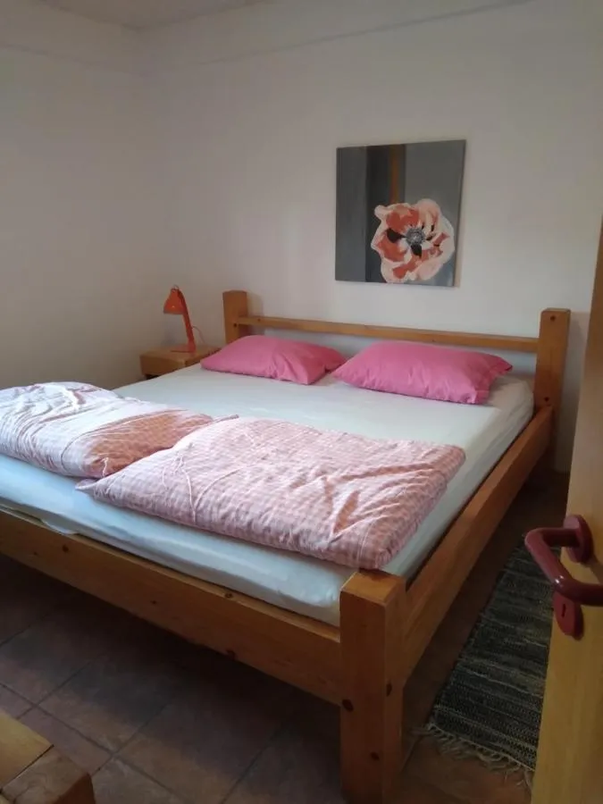 Postelja z rožnatim pregrinjalom