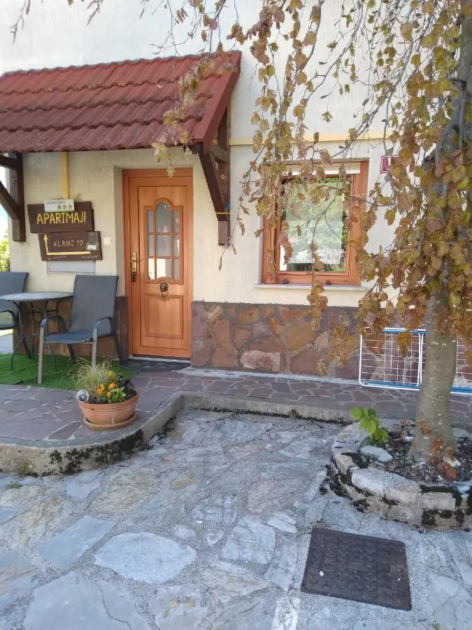 Lesena vhodna vrata v apartma, pred njimi kamnito dvorišče